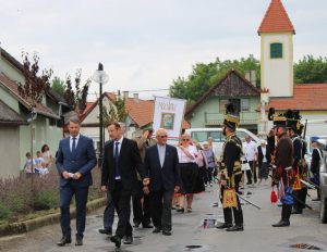 Vonulás a faluközpontban a koszorúzásra